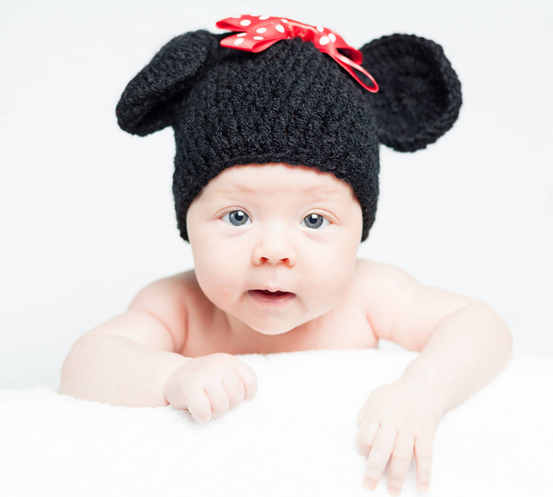 Neugeborenes Baby mit Hut auf dem Kopf auf Decke liegend - Foto, Bild