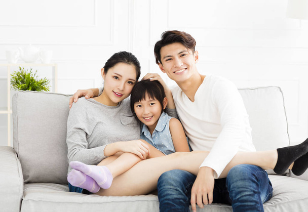 Aziatische en gelukkige familie op sofa in de woonkamer - Foto, afbeelding