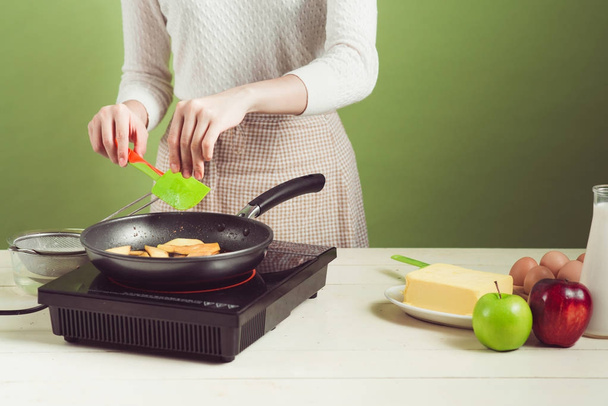 woman frying apple in pan - Zdjęcie, obraz