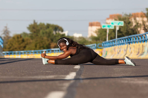 Νεαρή Αφρικανή γυναίκα κάνει σπορ στο δρόμο - Φωτογραφία, εικόνα