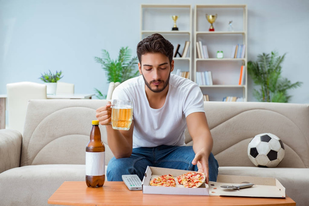 Hombre comiendo pizza teniendo una comida para llevar en casa descansando relajado - Foto, imagen