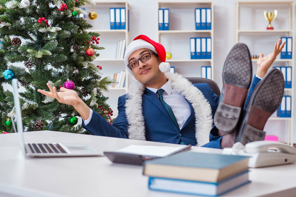 Бизнесмен празднует Рождество в офисе - Фото, изображение