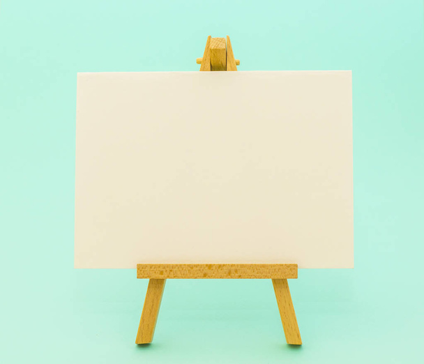 White paper on little easel on colorful background - Photo, Image