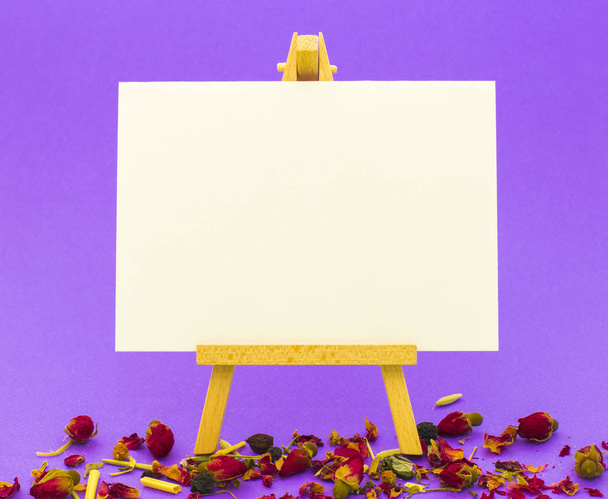 Küçük şövale üzerinde renkli arka plan üzerinde beyaz kağıt - Fotoğraf, Görsel