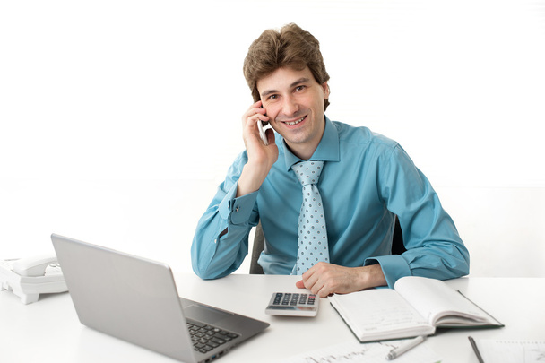 Businessman with phone and laptop at office - Φωτογραφία, εικόνα