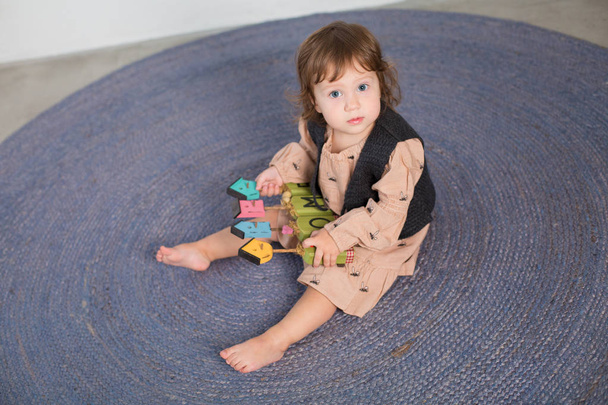 Little happy girl playing with toy on floor. - Фото, зображення