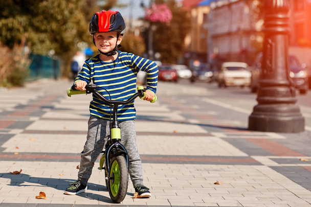 Glücklicher Junge fährt Fahrrad im Stadtpark - Foto, Bild