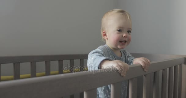 Baby in the crib looks around and smiles - Footage, Video