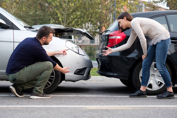 People examining car body damages after car hit - 写真・画像