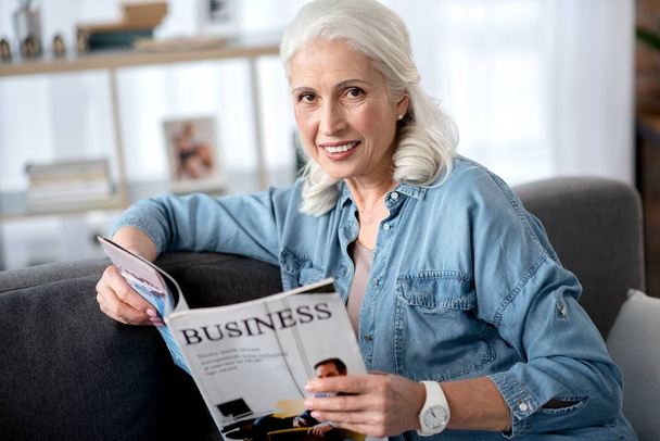 Cheerful mature woman is interested in business news - Фото, зображення