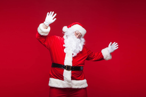 Santa Claus is dancing Isolated on red background. - Foto, afbeelding