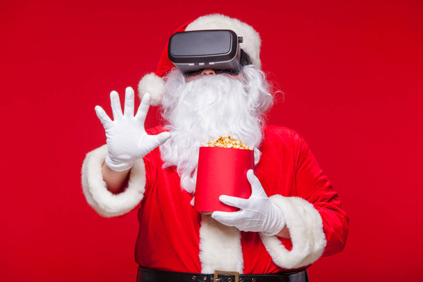Santa Claus wearing virtual reality goggles and a red bucket wit - Fotó, kép