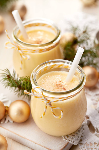 Eggnog alcoholic beverage served with cinnamon or nutmeg.  Traditional drink often served during Christmas - Foto, Imagen