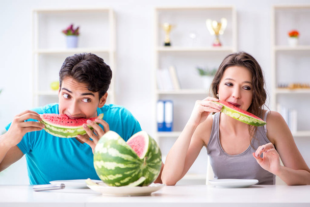 Homme et femme mangeant pastèque à la maison - Photo, image