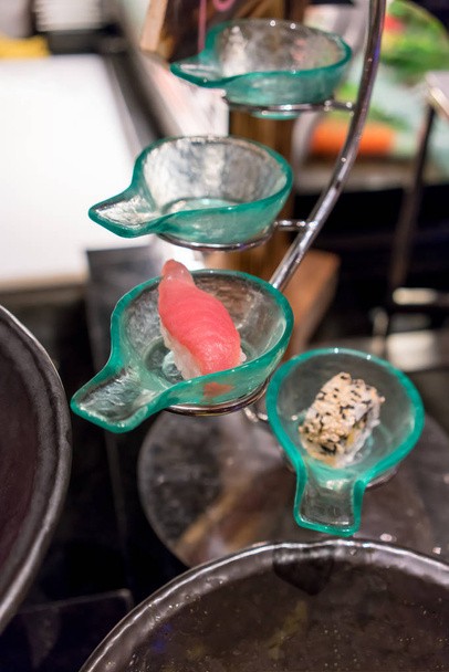 Sushi au thon fermé dans un bol en verre en forme de cuillère placé sur une bougie
 - Photo, image