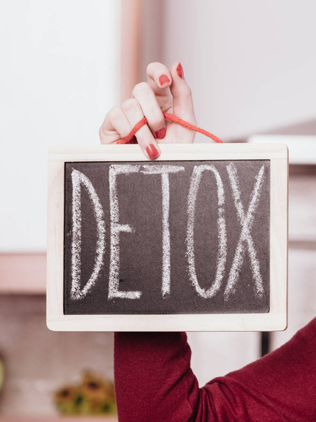 Happy woman holding board with detox sign - Фото, изображение