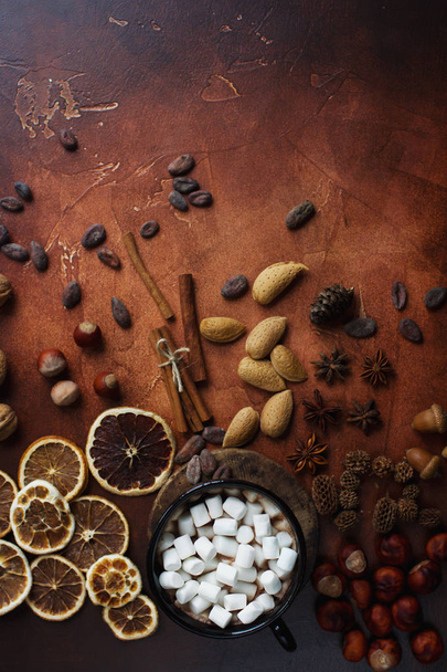 Чашка традиційного гарячого шоколаду або какао з зефіром, корицею, горіхами та спеціями на темному кам'яному столі
 - Фото, зображення