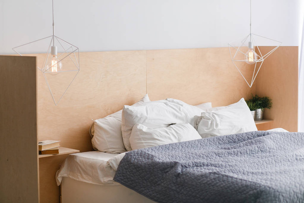 Μαύρο και άσπρο κρεβάτι με ξύλινο bedhead loft εσωτερικό, γεωμετρικό φώτα - Φωτογραφία, εικόνα