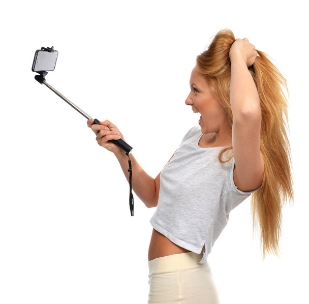 Portrait of beautiful red hair woman making selfie with stick  - Zdjęcie, obraz