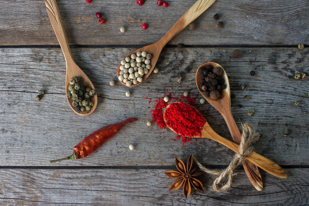 pepper mix in wooden spoons on rustic table, colorful indian spices - Zdjęcie, obraz