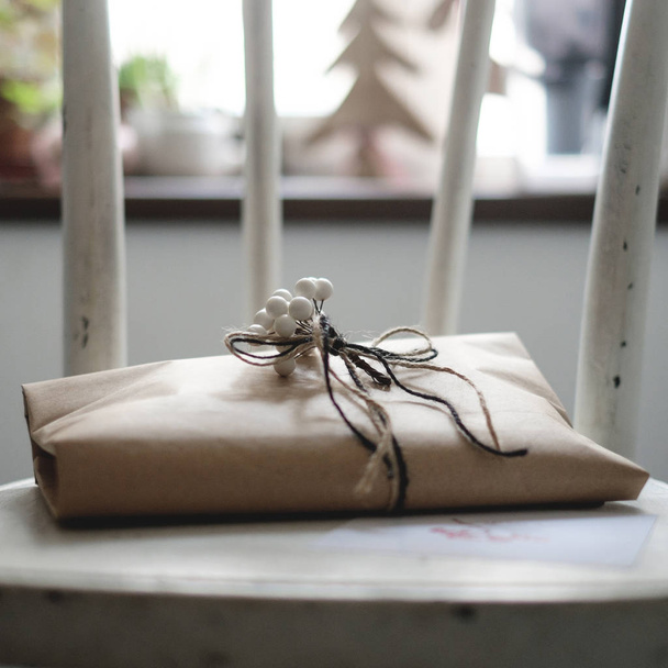 Gift rustic decorated Christmas gift with a white branch of mountain ash - 写真・画像