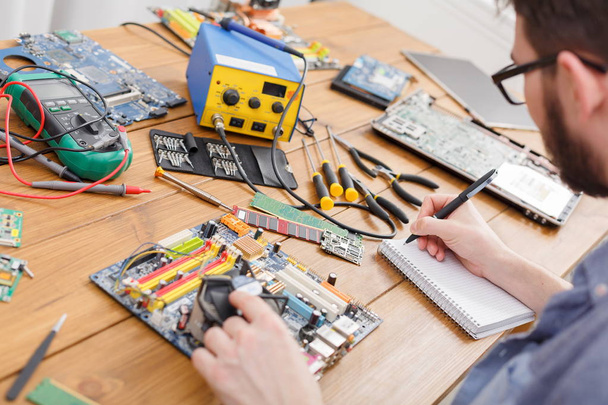 Electronic circuit board inspecting in repair shop - Foto, imagen