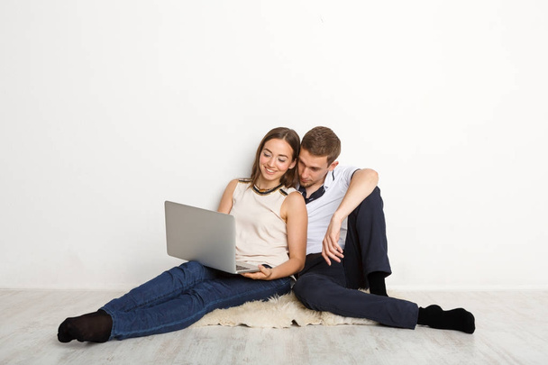 Χαρούμενο ζευγάρι χρησιμοποιώντας φορητό υπολογιστή στο σπίτι, αντίγραφο χώρου - Φωτογραφία, εικόνα