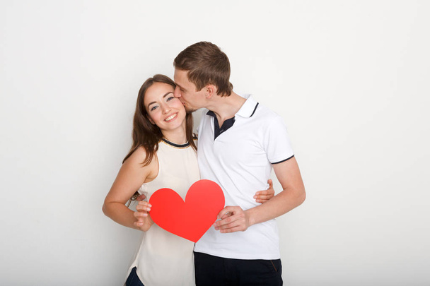 Joven feliz pareja enamorada sosteniendo el corazón de papel rojo - Foto, Imagen