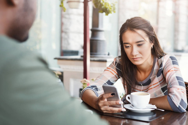 Joven chica aburrida bebiendo café en una cita en un café
 - Foto, imagen