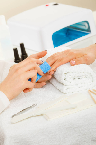 Woman getting manicure done file nails - Fotoğraf, Görsel