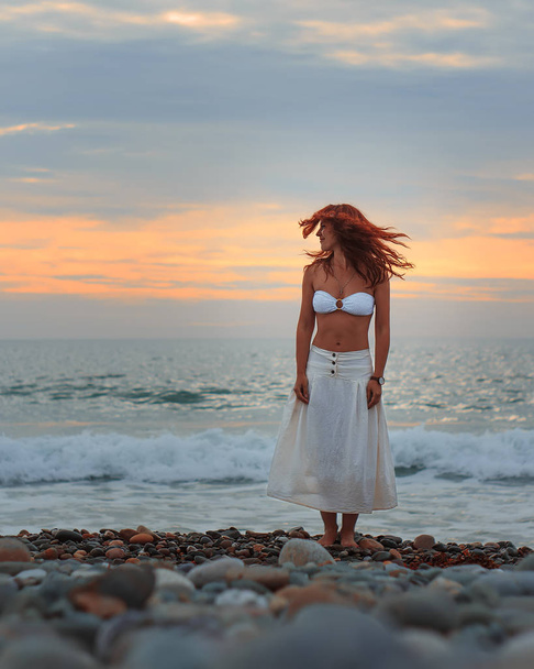 woman standing on beach and looking over shoulder - Fotó, kép