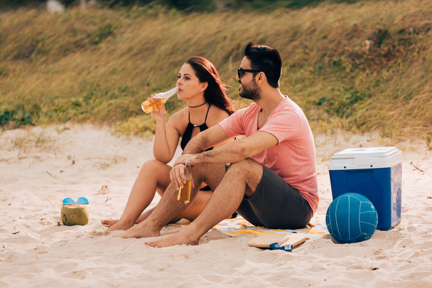 Couple drinking beer and having fun on the beach - Zdjęcie, obraz
