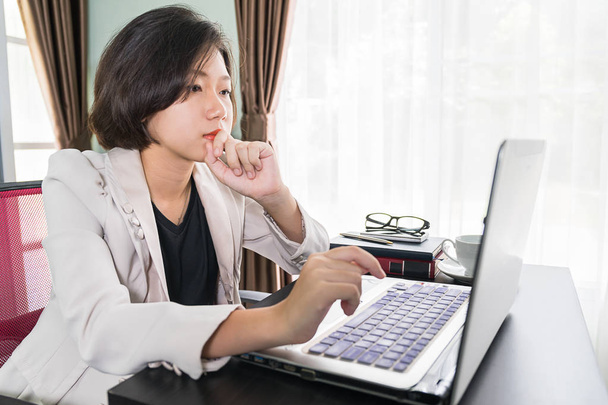 Jeune femme en tenue décontractée intelligente travaillant sur ordinateur portable
 - Photo, image
