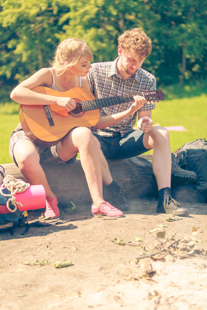 Young couple camping playing guitar outdoor - Photo, Image