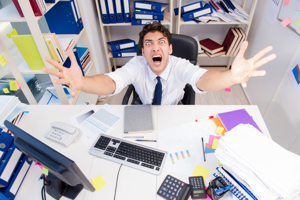 Businessman working in the office with piles of books and papers - Photo, Image