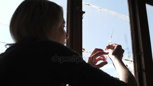 Silueta depresivní tvář dívky přemýšlet o stříkačku s heroinem - Záběry, video