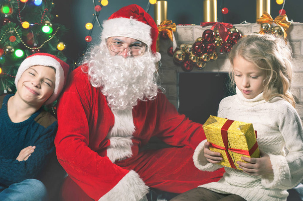 Kids around Santa Claus tell him they wishes, Christmas eve - 写真・画像