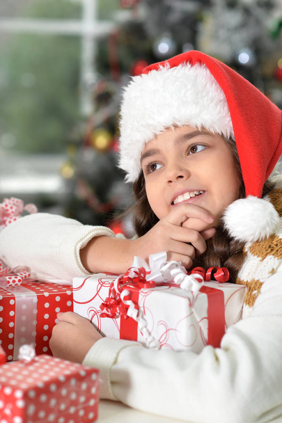  girl in Santa hat with gifts - Фото, изображение