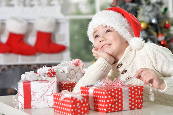 Хлопчик в Санта hat з подарунками - Фото, зображення
