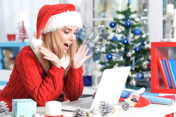 woman in Santa hat  using laptop - Фото, изображение