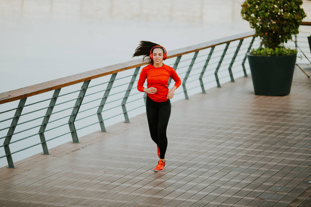 Active young beautiful woman running on the promenade  - Valokuva, kuva