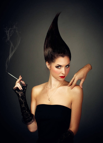 Helloween. Mysterious woman in dark hood with cigarette - Fotó, kép