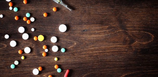 Drogues et pilules sur une table en bois. Différents moyens pour prévenir le froid
 - Photo, image