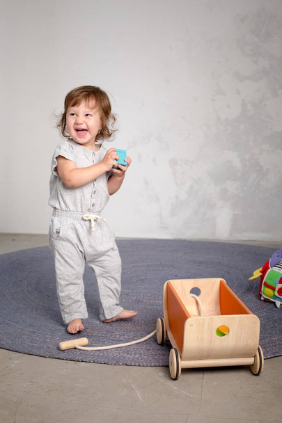Petite fille heureuse jouant avec un jouet sur le sol
. - Photo, image