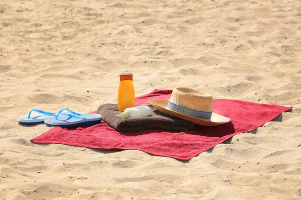 Summer composition with red beach towel on sand - Foto, afbeelding