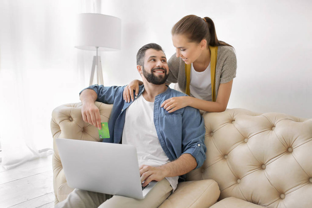 Young couple with laptop at home. Internet shopping concept - Valokuva, kuva
