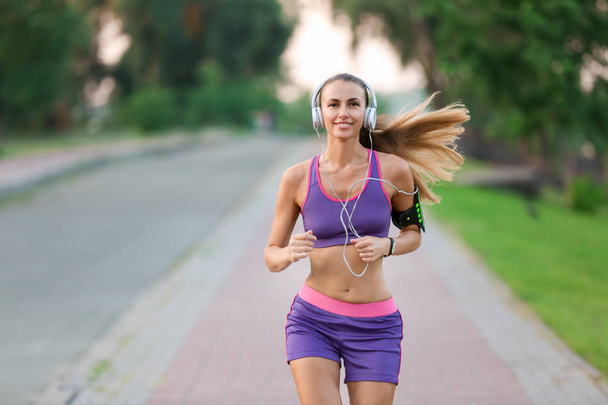 Young sporty woman running in park - Φωτογραφία, εικόνα