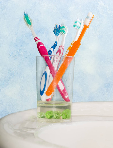 Πολλές διαφορετικές οδοντόβουρτσες σε ποτήρι για οδοντόβουρτσες - Φωτογραφία, εικόνα