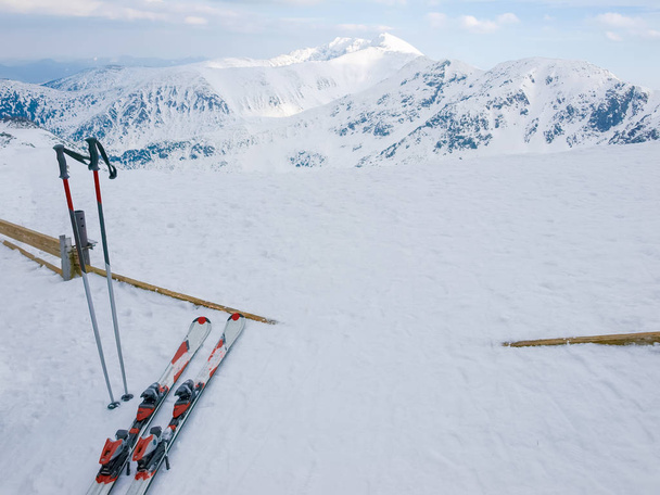 A neve cobriu montanhas e esquis alpinos em primeiro plano
 - Foto, Imagem