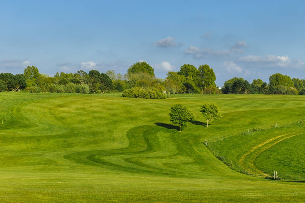 Vista geral de um campo de golfe verde em um dia ensolarado brilhante. Paisagem de verão idílica. Esporte, relaxamento, recreação e lazer conceito
 - Foto, Imagem